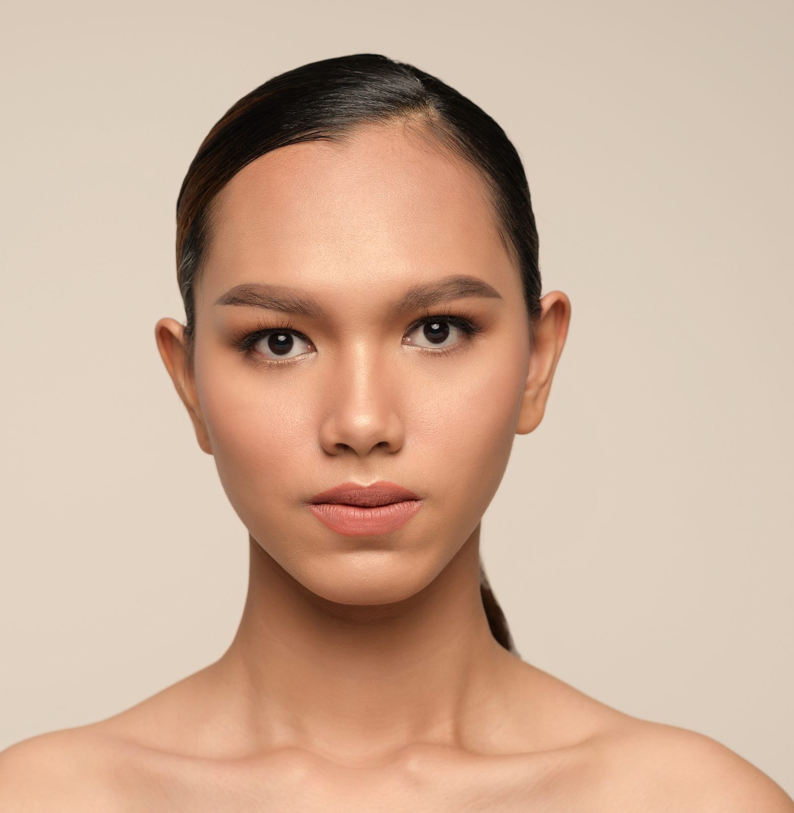 Close portrait of a woman with luminous natural makeup and sleek hair